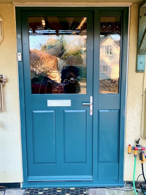 Bespoke solid timber front exterior entryway door integrated with custom colorful stained glass panes
